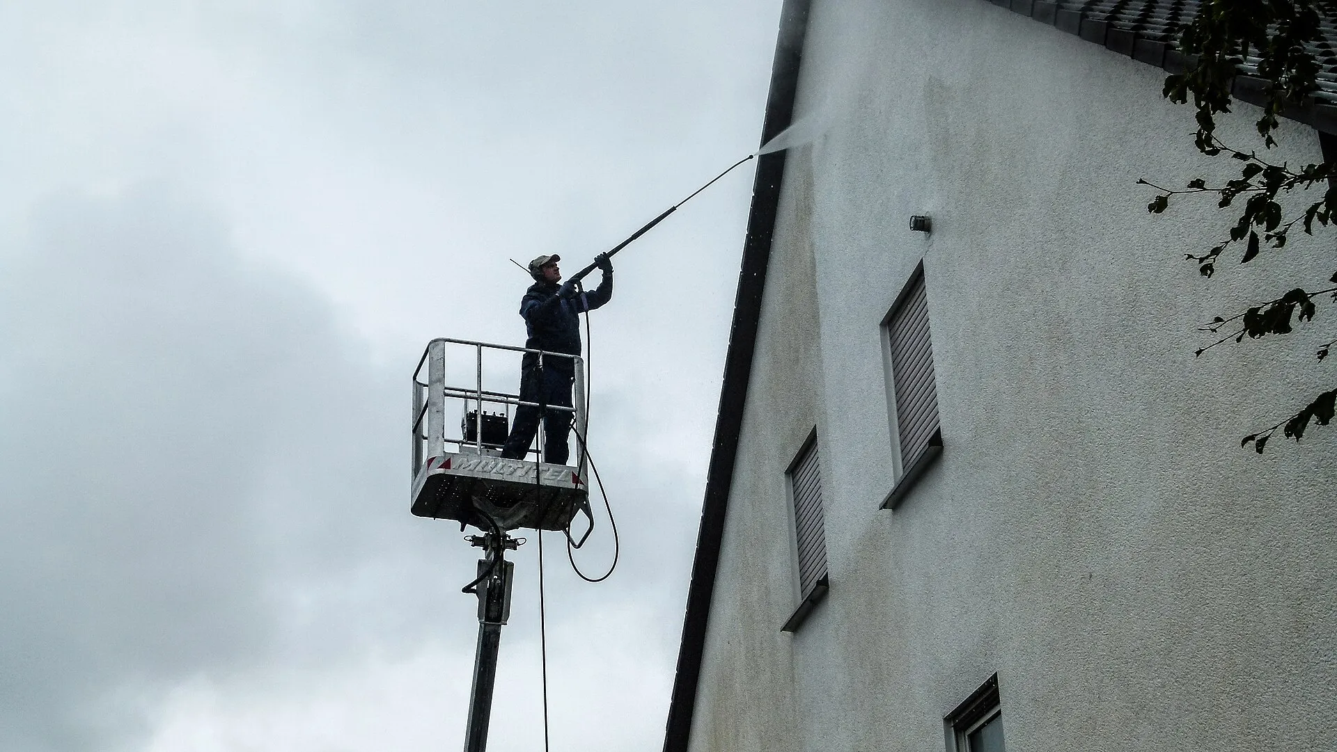 Fassadenreinigung: Reinigung einer Hausfassade mit Teleskoplanze von der Hebebühne